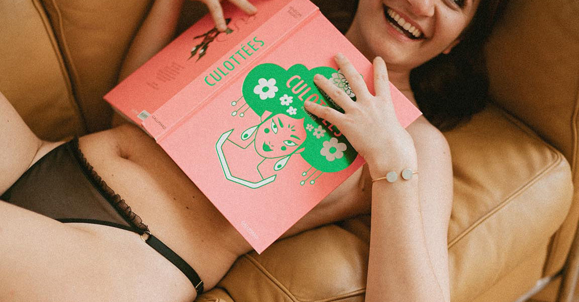 Femme cachant sa poitrine avec un livre.