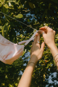 Brassière Lila rose poudré pendue à un fil à linge